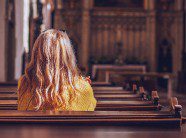 woman sitting in the pews of a church